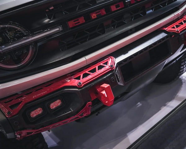 Custom Ford Bronco desert racing at high-speed on a washboard trail equipped with a lightweight TAMER4X4 TITAN series dry carbon fiber front bumper and vented hood to prevent 4x4 metal fatigue.